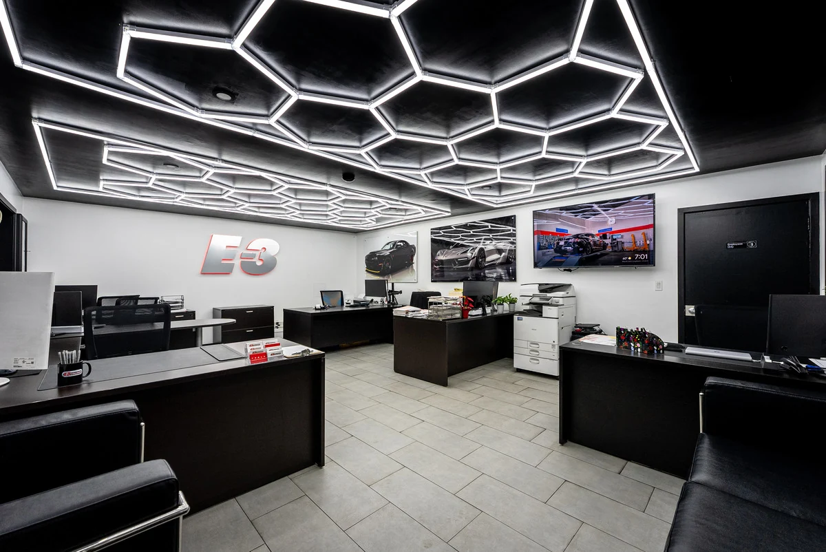 E3’s reception area with black seating and geometric ceiling lights